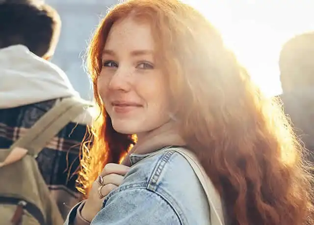 Ragazza dai capelli rossi che guarda sorridendo